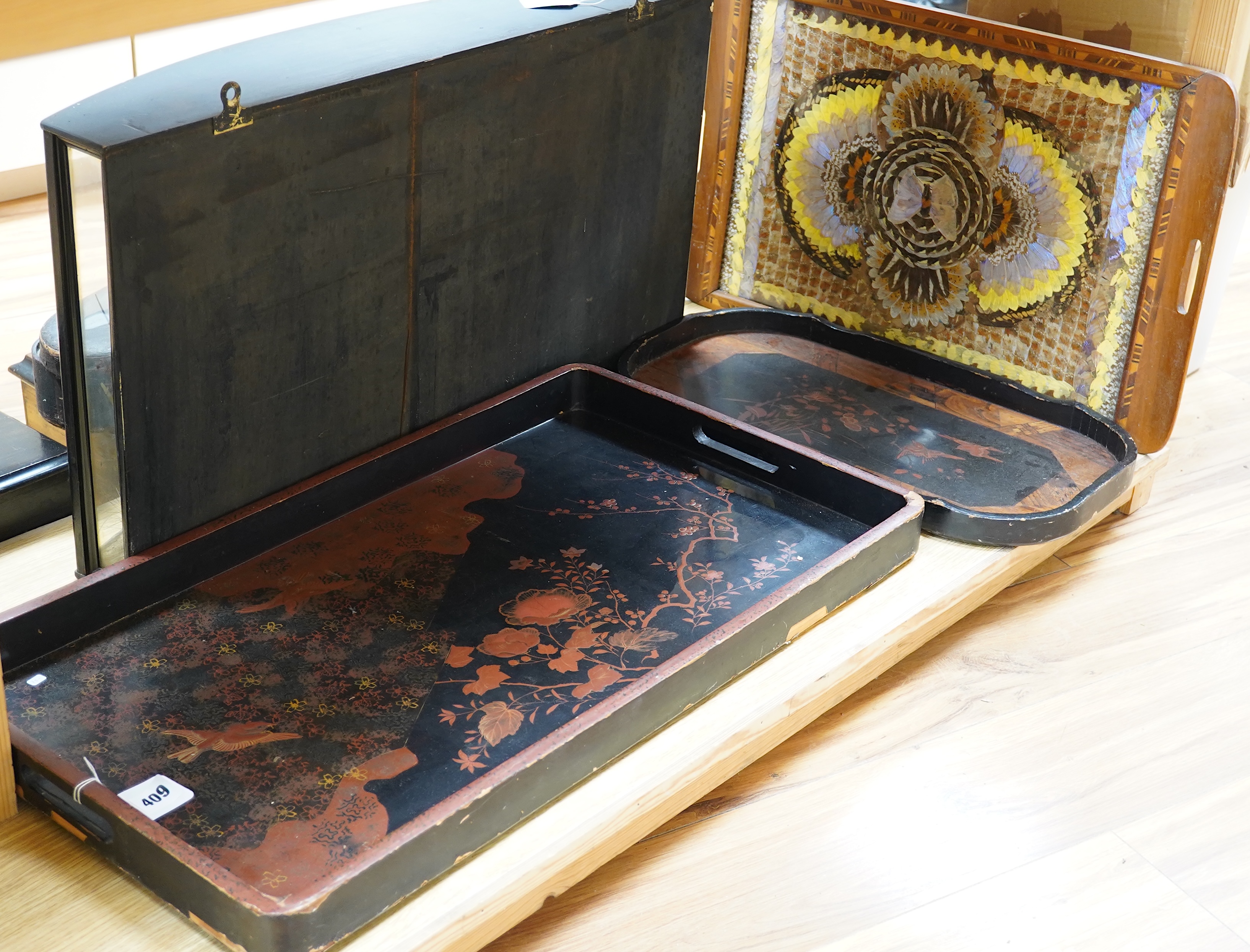 Three trays to include a butterfly wing example and a Japanese lacquered example decorated with birds and flowers, 75cm wide. Condition - poor to fair